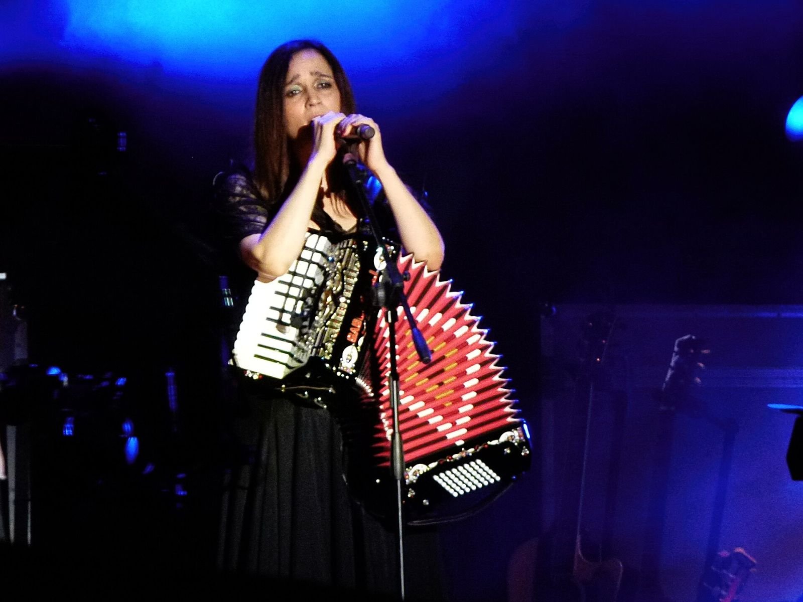 Julieta Venegas cantando con acordeón durante un concierto